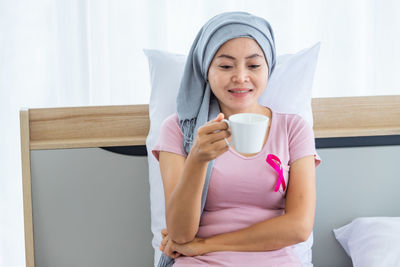 Young woman drinking water from coffee cup