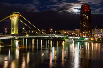 Illuminated raft bridge over river main in city at night