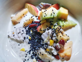 Mixed fruits with milk in bowl seasoning with black sesame for dieting