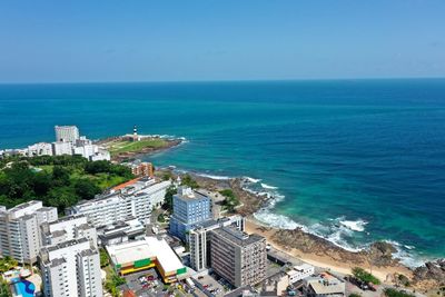 High angle view of city by sea against clear sky