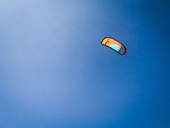 Low angle view of kite flying against blue sky