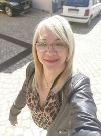 High angle portrait of woman with blond hair standing on street