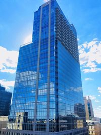 Low angle view of skyscrapers against blue sky