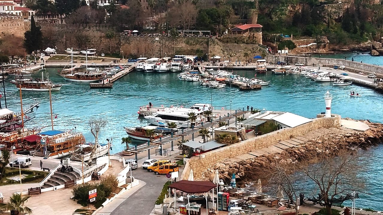 water, nautical vessel, building exterior, moored, built structure, transportation, architecture, mode of transport, boat, high angle view, harbor, house, day, town, tree, outdoors, lake, river, no people, sunlight