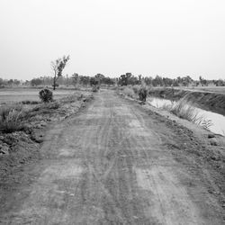 Dirt road against clear sky