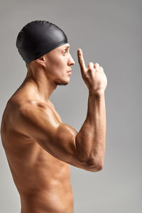 Side view of shirtless man against gray background