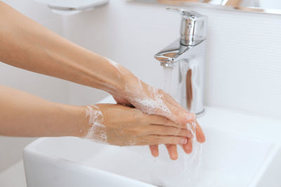 Cropped hands washing hand in sink