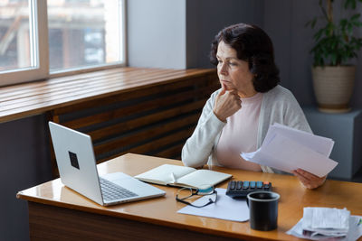 Side view of businesswoman working at office