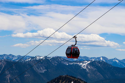 Overhead cable car over snowcapped mountains against sky