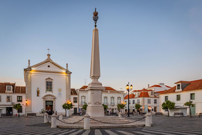 Statue of buildings in city against clear sky