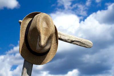 Low angle view of hat on rock against sky