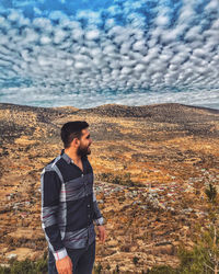 Young man standing on land against sky