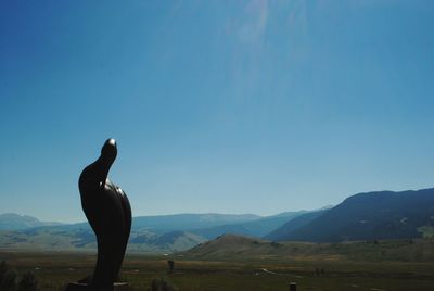 Man standing on mountain against blue sky
