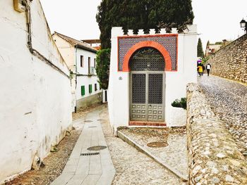 Footpath amidst buildings in city