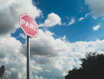 Low angle view of road sign against sky