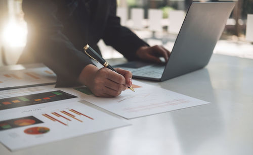 Midsection of businessman working on table