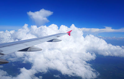 Airplane wing against cloudy sky