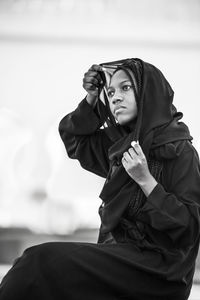 Close-up of young woman against sky
