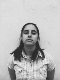 Portrait of young woman against wall