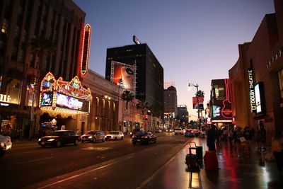 Vehicles on road along buildings in city