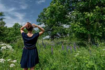 Full length of woman standing in a meadow