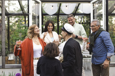 Happy family welcoming young man at summer party