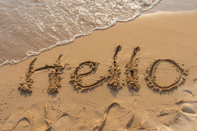 High angle view of text on sand at beach