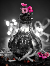 Close-up of illuminated flower in glass vase on table