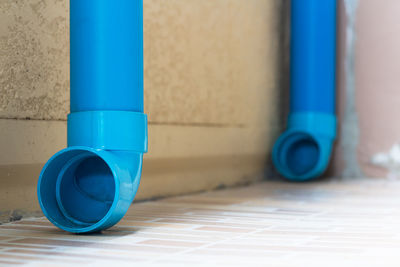 Close-up of blue pipe on tiled floor