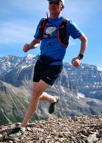 Full length of man climbing rock on mountain against sky