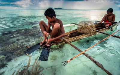 Men sitting on boat in sea