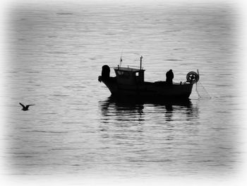 Silhouette people in boat on sea
