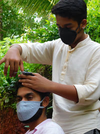 One man's cutting hair of other one with all safety precautions in this corona pandemic period 