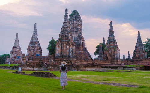 Rear view of woman standing on field against sky