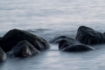 Rocks in sea against sky