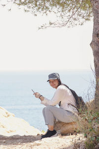 Rear view of woman sitting on beach