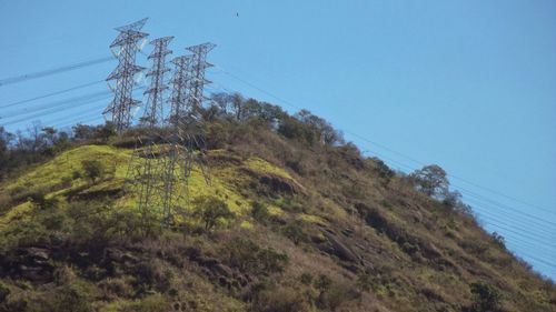 Low angle view of electricity pylon against clear sky