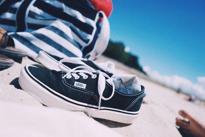 Close-up of shoes on beach