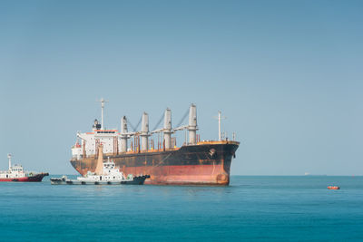 Ship in sea against clear blue sky