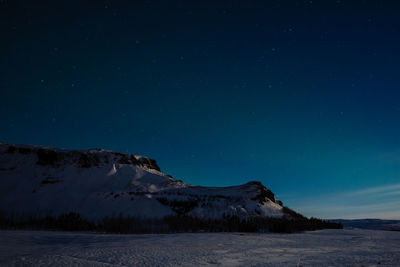 Scenic view of snowcapped mountains against sky at night