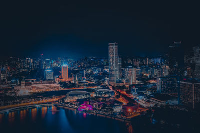 Illuminated buildings in city against sky at night