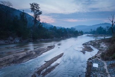 Scenic view of river by snowcapped mountains against sky