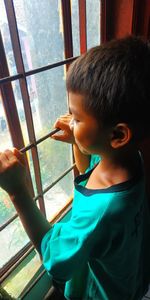 Boy looking through window