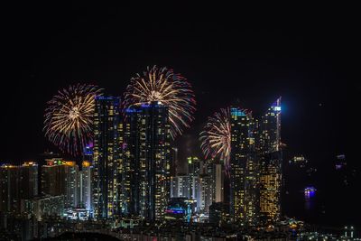 High angle view of colorful firework display over illuminated city at night