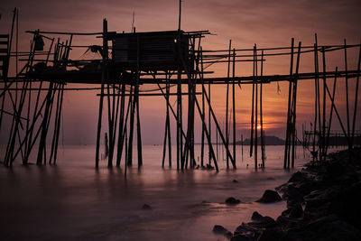 Silhouette pier on sea against sky during sunset