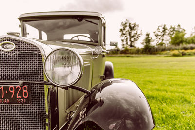 Vintage car on field against sky