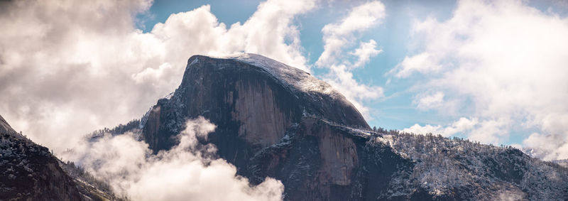 Low angle view of clouds over mountains against sky