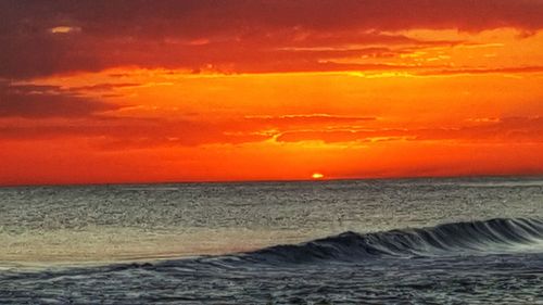 Scenic view of sea against orange sky