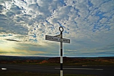 Information sign on road against sky