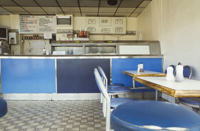 Empty chairs and table against wall